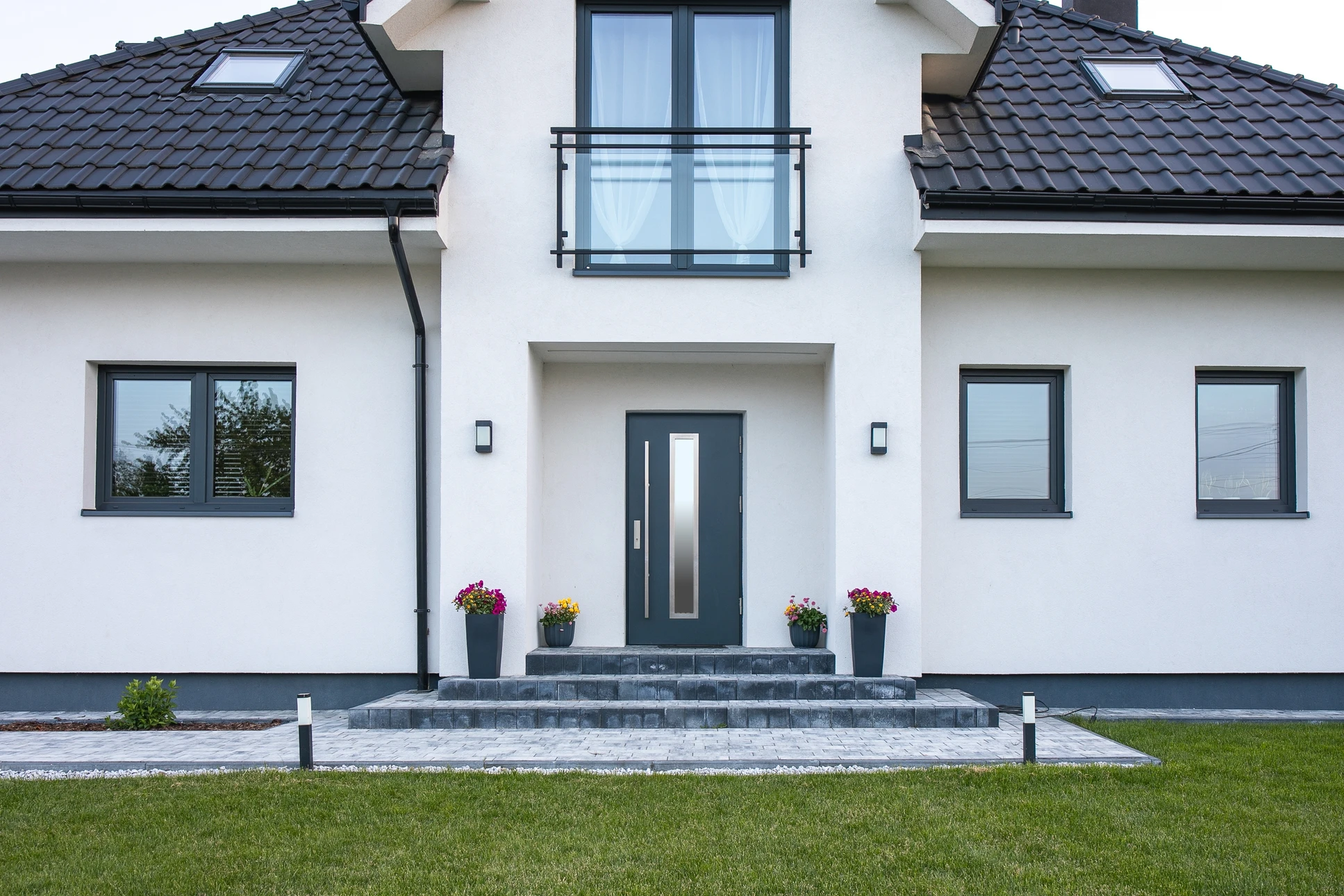 Fontaine d'eau contemporaine avec deux jets verticaux jaillissant d'ouvertures rectangulaires intégrées dans un mur de pierre naturelle grise